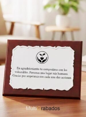 Placa conmemorativa de aluminio con bordes decorados sobre base de madera lustrada, modelo 4622 de Multigrabados, con texto de agradecimiento personalizado.