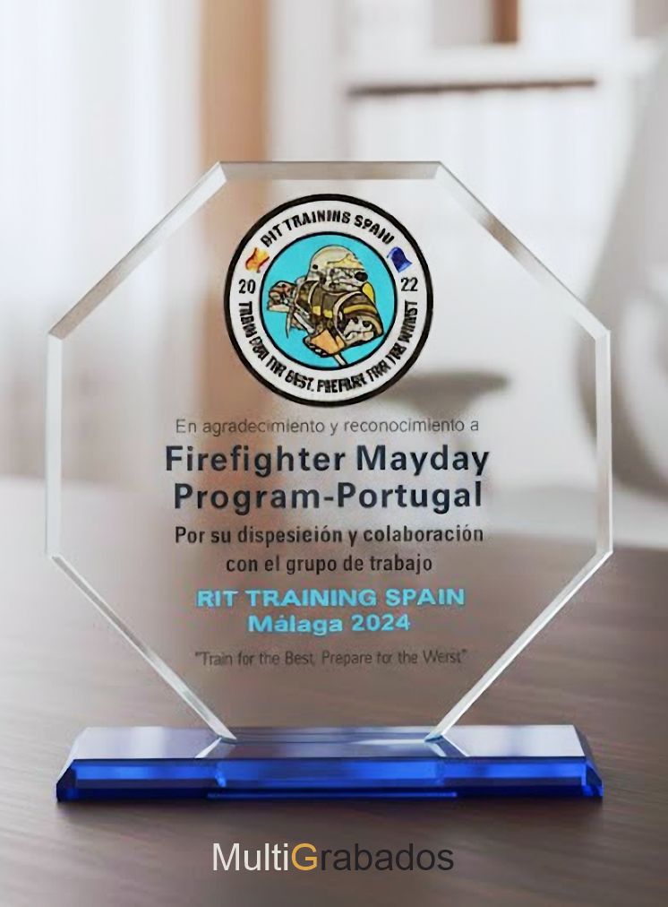 Trofeo de cristal óptico transparente con detalle decorativo en azul en la base, personalizado para eventos de reconocimiento y premios corporativos.