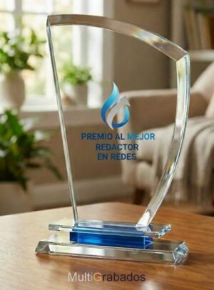 Trofeo de cristal óptico con silueta de vela náutica, detalle de base en azul translúcido y grabado personalizado para premios de comunicación y redes sociales